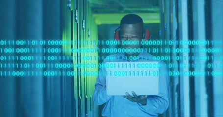 Poster - Animation of binary codes, african american engineer with headphone and laptop looking at servers