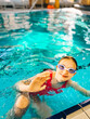 © Анна Молько - a girl in a pink swimsuit and swimming goggles in the pool