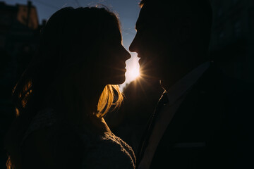 Wall Mural - silhouettes of the bride and groom and the sun's rays between th