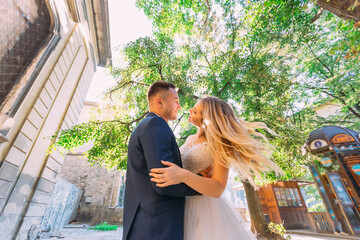 Wall Mural - the groom hugs the bride by the waist and she waves her hair. ne