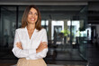 © Stock 4 You - Beautiful hispanic senior business woman with crossed arms smiling, looking aside. European Latin confident mature good looking middle age leader female businesswoman on office background, copy space.