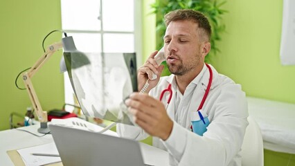 Poster - Young man doctor talking on telephone holding xray at clinic