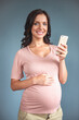 © georgerudy - Beautiful pregnant woman with gadget