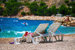 Leżaki na słonecznej plaży nad błękitnym tropikalnym morzem. 