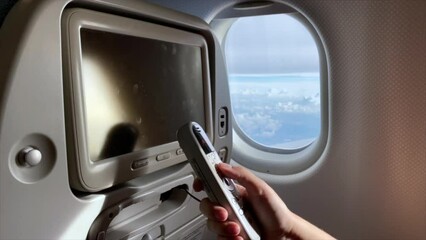 Plane passenger using remote control of seat monitor during the flight