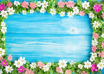 Wall Mural - Blooms of Beauty: A Frame of Many Flowers Adorning Blue Wood - Explore a captivating scene where a multitude of flowers come together to grace a charming blue wood background.