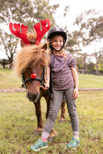 Young Girl With Horse Dressed As Reindeer For Christmas