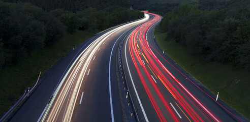 Car lights at dusk on the highway.