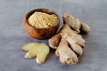 Wall Mural - Ginger root and ginger powder on grey background