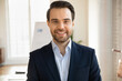 © fizkes - Close up headshot portrait of smiling Caucasian young businessman in formal suit pose in office, profile picture of happy confident male boss or director show success at workplace, leadership concept