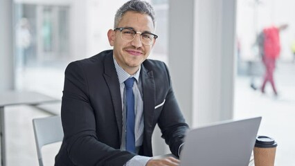 Canvas Print - Young hispanic man business worker using laptop working at office