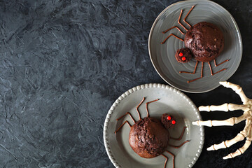 Poster - Spooky Halloween spider muffins. Above view over a dark slate background with copy space.