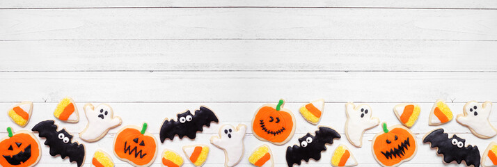 Aufkleber - Halloween cookie bottom border. Top view on a white wood banner background with copy space. Ghosts, bats, jack o lanterns and candy corn.