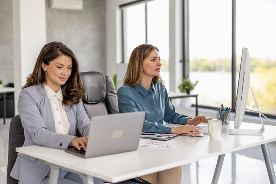 Business women working together on computer in modern office