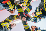 Fototapeta Przeznaczenie - Fire fighter men and women doing some teambuilding stacking hands