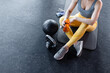 © Kzenon - fit and beautiful young woman in sport clothes sitting on the floor of a gym beside a kettle bell having a phone and water bottle in her hand