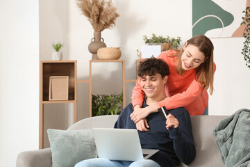 Poster - Young couple with laptop shopping online at home