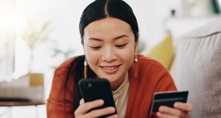 Poster - Asian woman, credit card and phone relaxing on her sofa online shopping, ecommerce and fintech easy payment. Young person in China typing bank information on cellphone for finance transaction at home