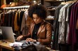 black woman writing in her laptop at her clothing store
