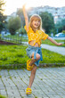 © Andrii Iemelianenko - Preteen child kid shouting, celebrating success, winning, goal achievement, good news, lottery jackpot luck, victory, play game. Blonde little girl jumping on city sunset street, outdoors. Vertical