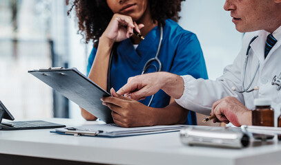 Wall Mural - Medical staff team african american meeting discussing chest x-ray film Radiologists medical doctors that specialize in diagnosing, treating injuries, diseases, radiology, procedures exams, tests