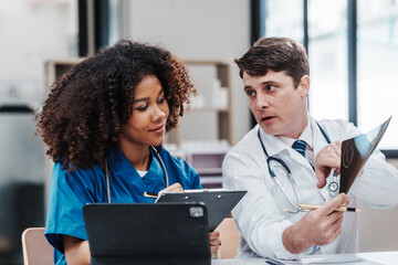 Wall Mural - Medical staff team african american meeting discussing chest x-ray film Radiologists medical doctors that specialize in diagnosing, treating injuries, diseases, radiology, procedures exams, tests