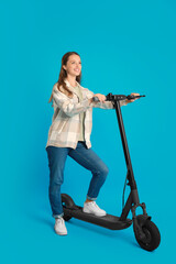 Poster - Happy woman with modern electric kick scooter on light blue background