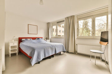 Wall Mural - a bedroom with a bed, desk and chair in front of the window that looks out to the garden outside