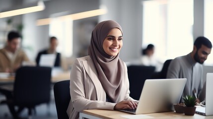 Wall Mural - arab saudi person using a laptop computer on her desk office