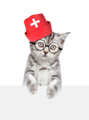 Aufkleber - Cat dressed like a doctor looks above empty white banner. isolated on white background