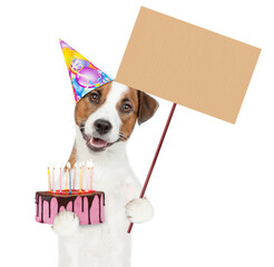 Poster - Jack russell terrier puppy wearing party cap holds cake with lots burning candles and shows empty placard. isolated on white background