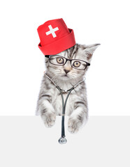 Poster - Tabby kitten dressed like a doctor with stethoscope on his neck looks above empty white banner. isolated on white background