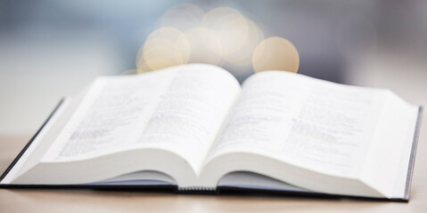 Religion, christian and bible book on a table for praying, spiritual faith or holy worship to God. Closeup of open scripture for studying, reading prayer or story of Jesus Christ hope or gospel