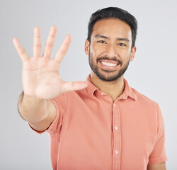 Poster - Smile, hand and portrait of man with stop gesture happy for communication isolated in a studio white background. Asian, sign language and confident young person with signal, symbol and hello sign