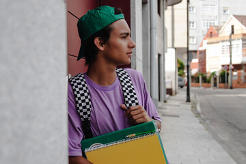 Wall Mural - teenage student with books and backpack leaning on the wall