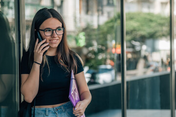 Wall Mural - teenage student girl using phone outside school