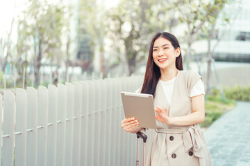 Wall Mural - Freelance young asian woman walking with travel luggage for business trip