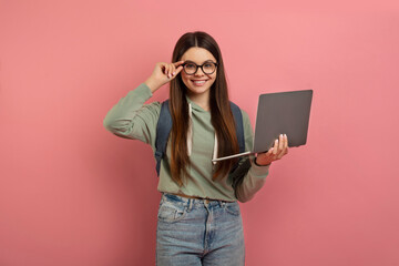 Portrait of smiling teen girl with laptop computer in hands