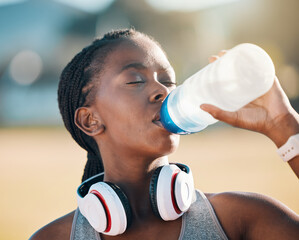 Poster - Black woman, drinking water and health, fitness and runner outdoor with headphones, thirsty after workout with cardio. Bottle, hydration and h2o, exercise and wellness with athlete, music and sports