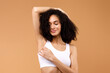 Hair removal concept. Happy latin lady demonstrating her armpit with smooth skin, posing in white underwear
