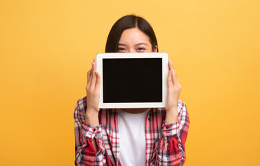 Poster - Happy japanese lady covering face with empty digital tablet computer, recommending new app or website, mockup