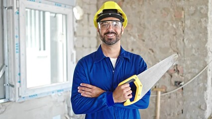 Sticker - Young hispanic man worker standing with arms crossed gesture holding shovel at construction site