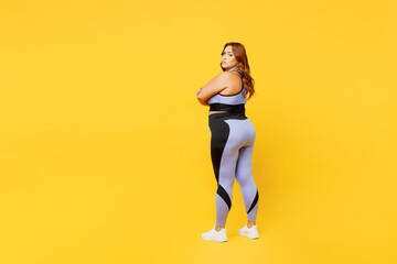 Wall Mural - Full body side back view young chubby plus size big fat fit woman wear blue top warm up training hold hands crossed folded isolated on plain yellow background studio home gym. Workout sport concept.