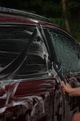 Wall Mural - washing a car outside, a red car at a car wash, outdoor