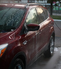 Wall Mural - washing a car outside, a red car at a car wash, outdoor