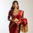 Portrait of a smiling woman in traditional red and golden saree holding gifts
