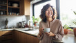 © MP Studio - Beautiful woman smiling with a cup of coffee in the kitchen of her home