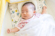 ベビーベッドで寝ている日本人の赤ちゃん