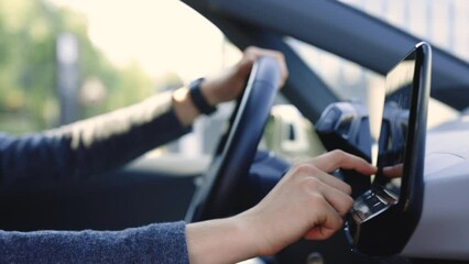 Unrecognizable man which typing needed coordinates on navigator touchscreen inside his auto. Young man sitting in front of the handlebar of his own luxury auto and applying navigator