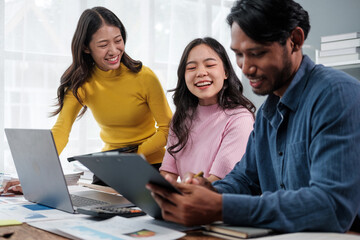 Poster - Group of young Asian business people brainstorming, looking at laptop computer.